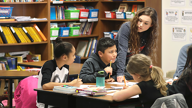 A teacher works with students in her fourth-grade classroom at Olympic View Elementary School, Friday, March 9, 2018, in Lacey, Wash. (AP Photo/Ted S. Warren)